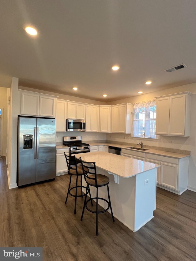 kitchen featuring a kitchen island, appliances with stainless steel finishes, sink, and white cabinets