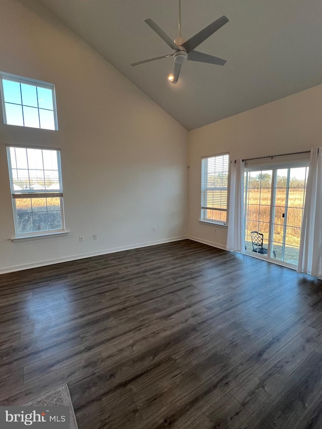 unfurnished room with dark hardwood / wood-style flooring, a wealth of natural light, high vaulted ceiling, and ceiling fan