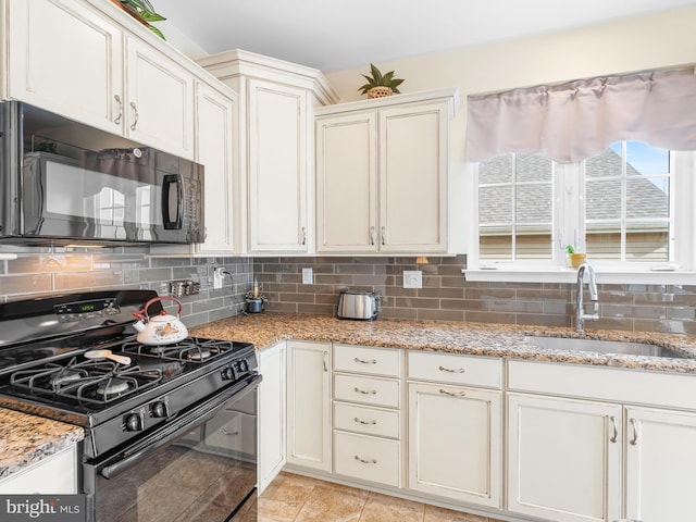 kitchen featuring light stone countertops, sink, backsplash, and black appliances