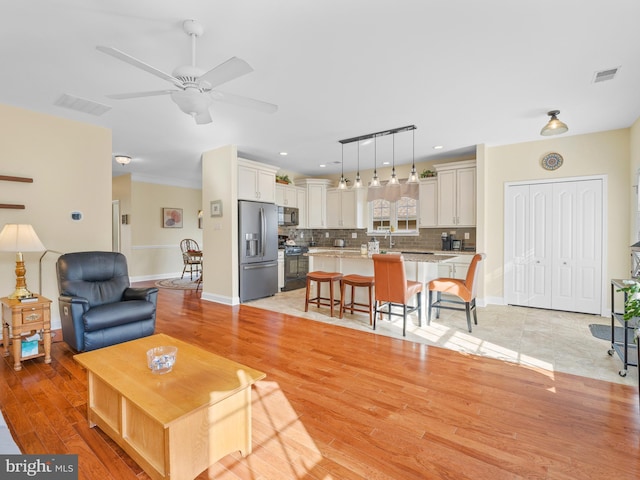 living room featuring light hardwood / wood-style floors and ceiling fan