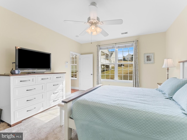 bedroom with ceiling fan and light carpet