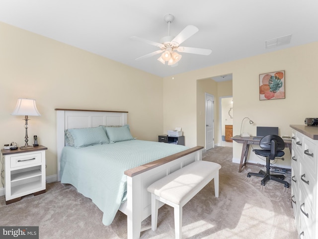 bedroom with connected bathroom, light carpet, and ceiling fan