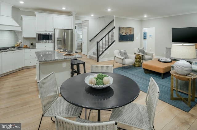 kitchen with white cabinetry, light stone countertops, stainless steel appliances, and premium range hood