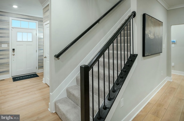 entrance foyer with ornamental molding and light wood-type flooring