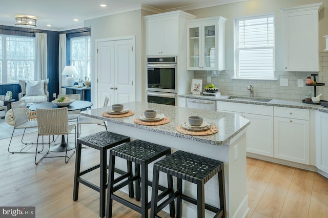 kitchen with white cabinetry, light stone countertops, sink, and appliances with stainless steel finishes