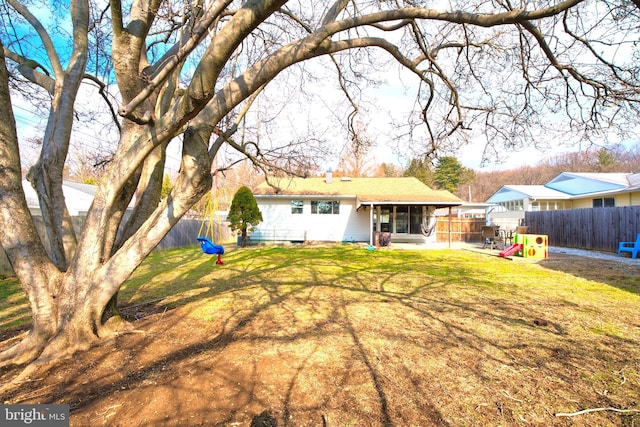 back of property featuring a yard and a playground