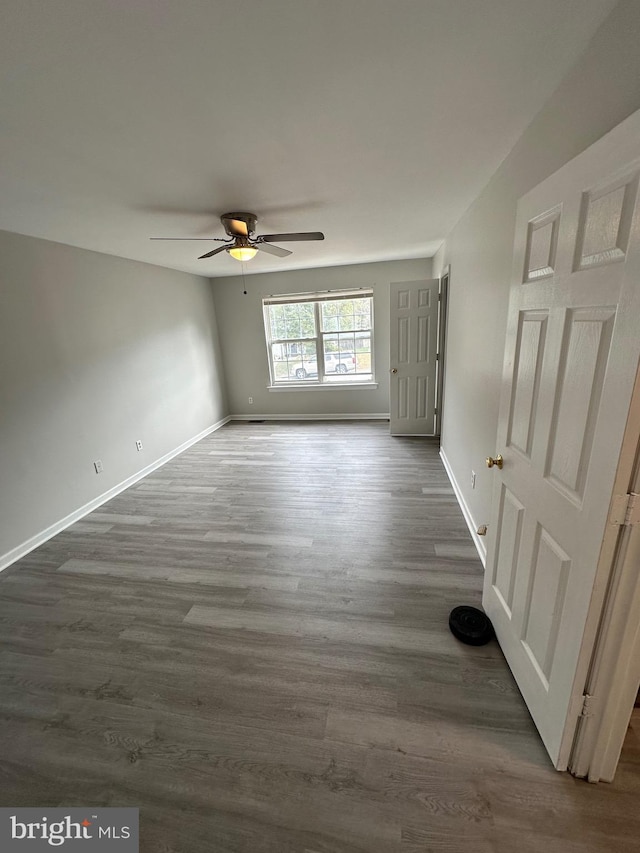 unfurnished room with dark hardwood / wood-style flooring and ceiling fan