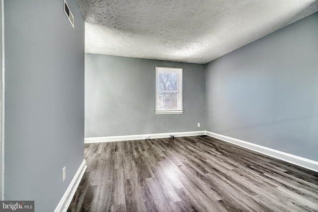 spare room with wood-type flooring and a textured ceiling