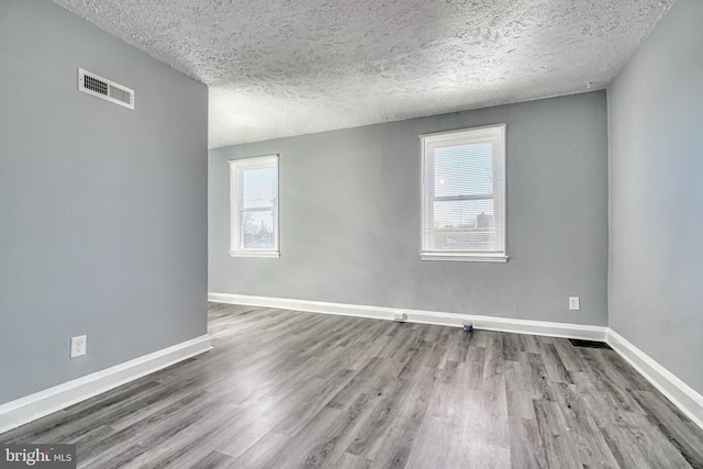 spare room with hardwood / wood-style flooring and a textured ceiling