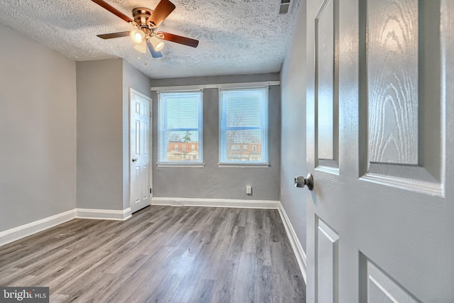 unfurnished room with hardwood / wood-style floors, a textured ceiling, and ceiling fan