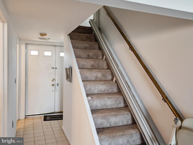 staircase featuring tile patterned flooring