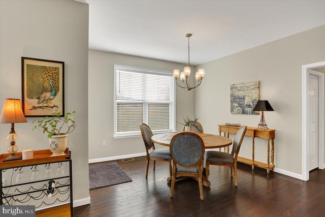 dining area featuring dark wood-type flooring and a chandelier