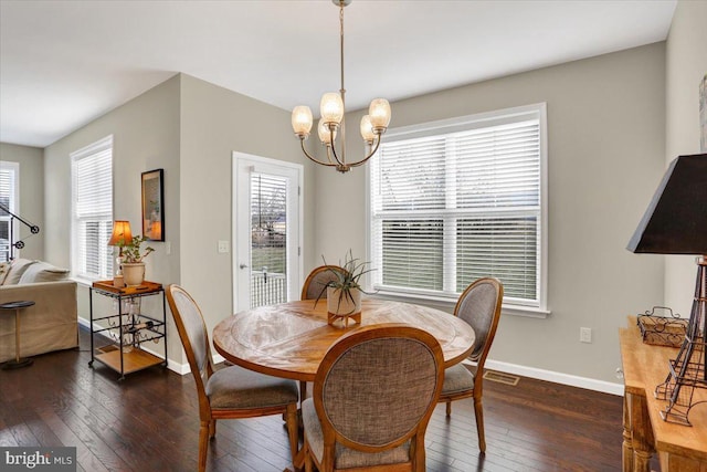 dining room with dark hardwood / wood-style floors and a chandelier