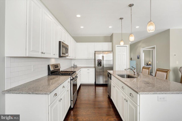 kitchen with sink, white cabinetry, decorative light fixtures, a center island with sink, and appliances with stainless steel finishes