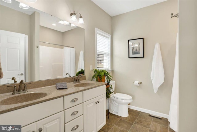 bathroom featuring walk in shower, vanity, and toilet