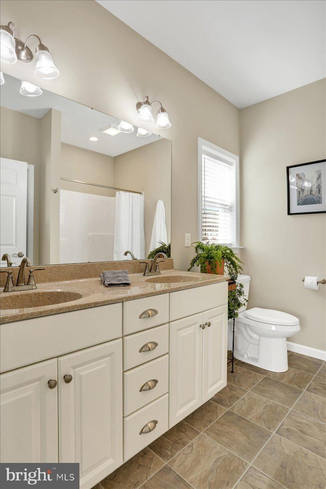 bathroom featuring walk in shower, vanity, and toilet