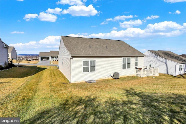 back of property with a yard and central air condition unit