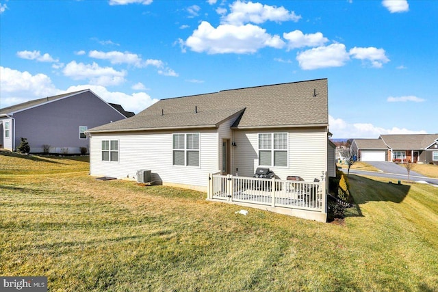 back of property with central AC unit and a lawn