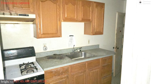 kitchen with white gas range and sink