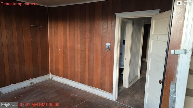 unfurnished room featuring wooden walls and dark hardwood / wood-style flooring