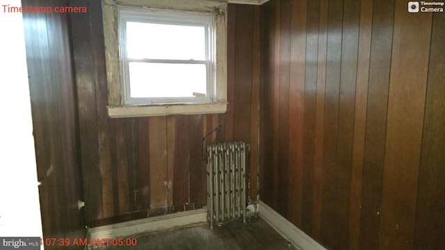 empty room with wooden walls and radiator