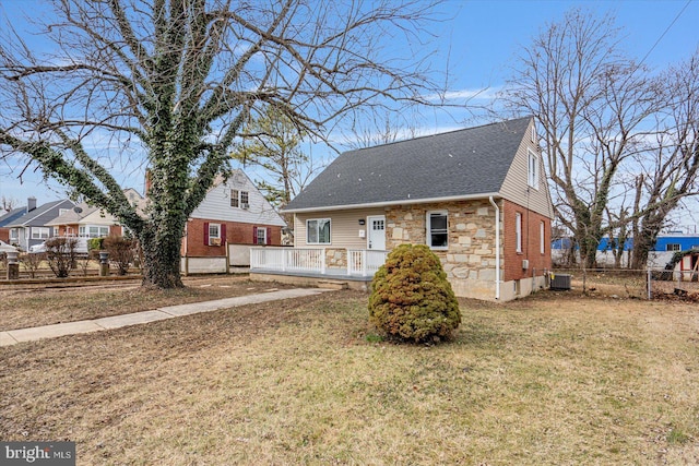 view of front of house with a wooden deck, central AC, and a front lawn