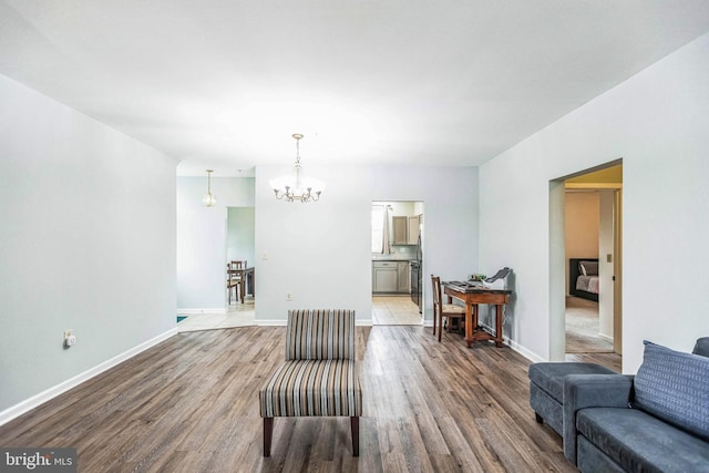 living area with hardwood / wood-style flooring and an inviting chandelier