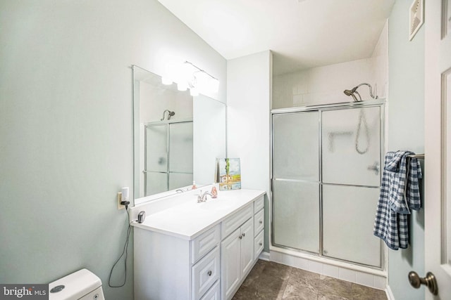 bathroom featuring an enclosed shower, vanity, and toilet