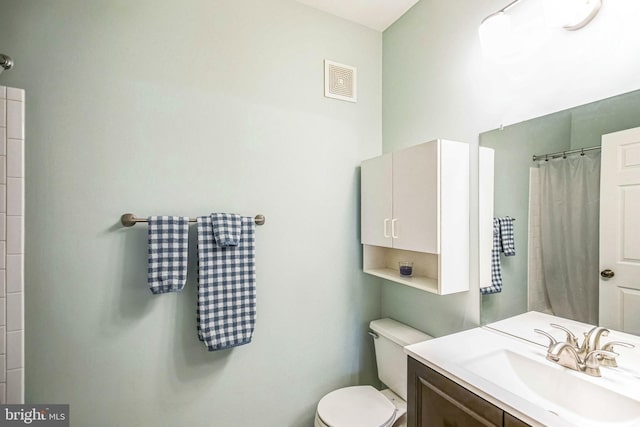 bathroom with a shower with curtain, vanity, and toilet