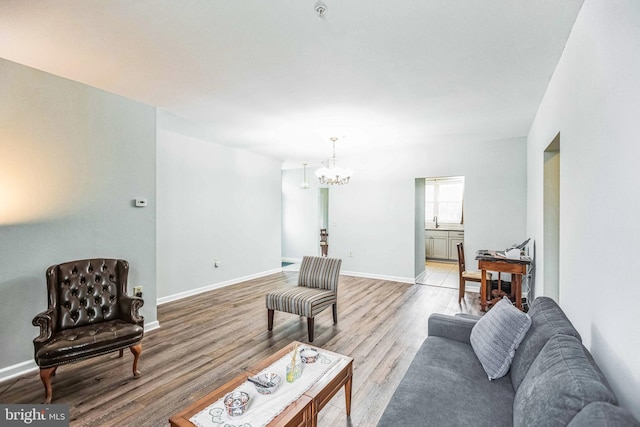 living room featuring a notable chandelier and light wood-type flooring