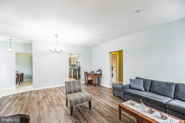 living room featuring an inviting chandelier and light hardwood / wood-style flooring