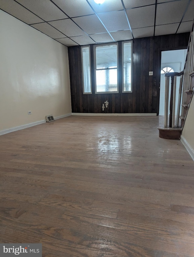 spare room with a drop ceiling and wood-type flooring