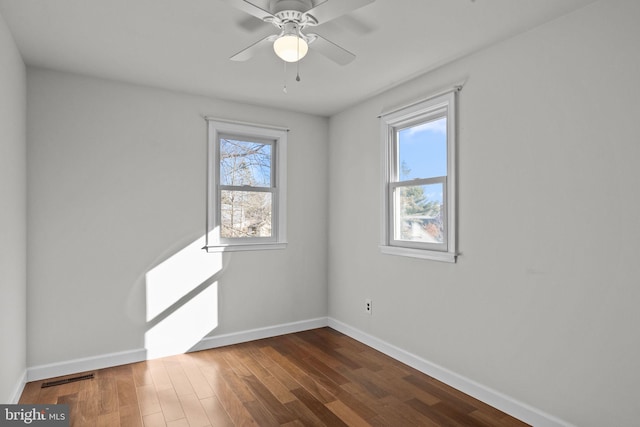 spare room with dark wood-type flooring and ceiling fan