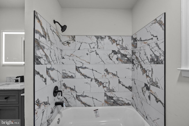 bathroom featuring tiled shower / bath combo and vanity