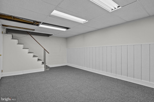 basement with carpet floors and a paneled ceiling