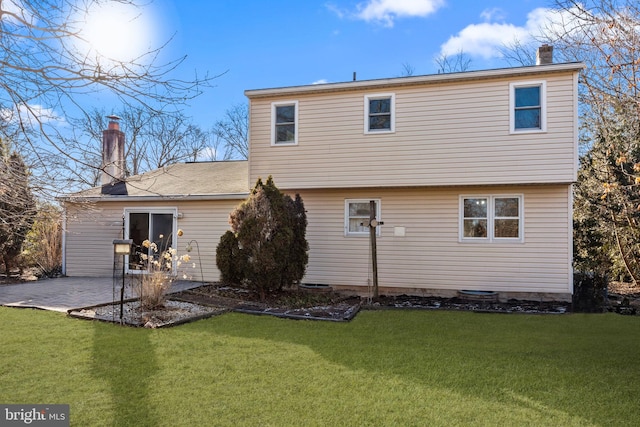 rear view of property featuring a patio and a lawn