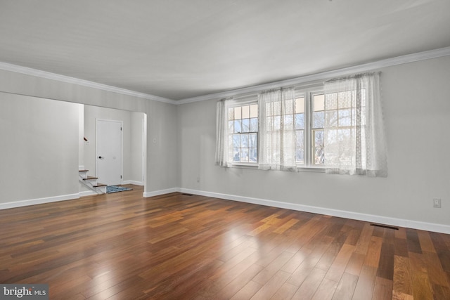 empty room featuring crown molding and dark hardwood / wood-style flooring