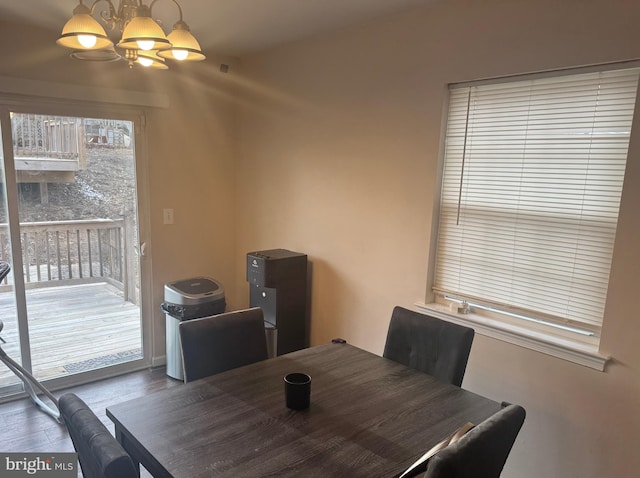 dining area featuring dark wood-style flooring and a notable chandelier