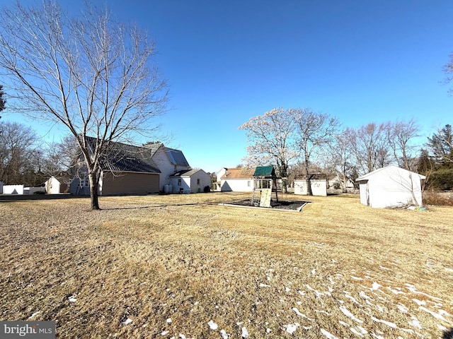 view of yard with a storage shed and a playground