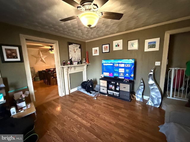 living room featuring crown molding, ceiling fan, and wood-type flooring