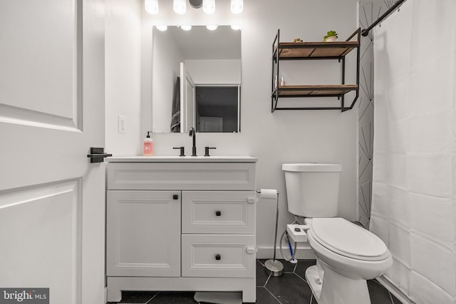 bathroom with tile patterned flooring, vanity, and toilet