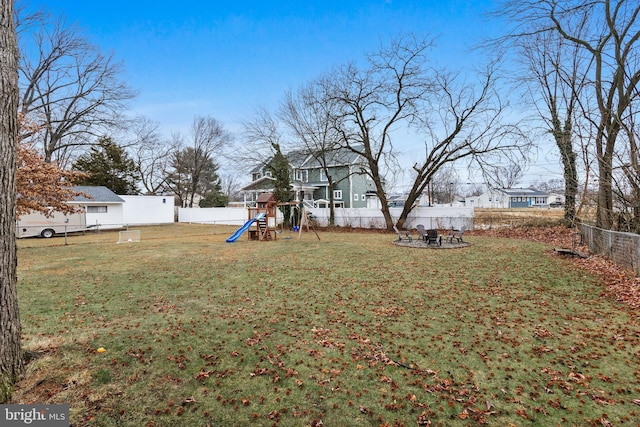 view of yard featuring a playground and an outdoor fire pit