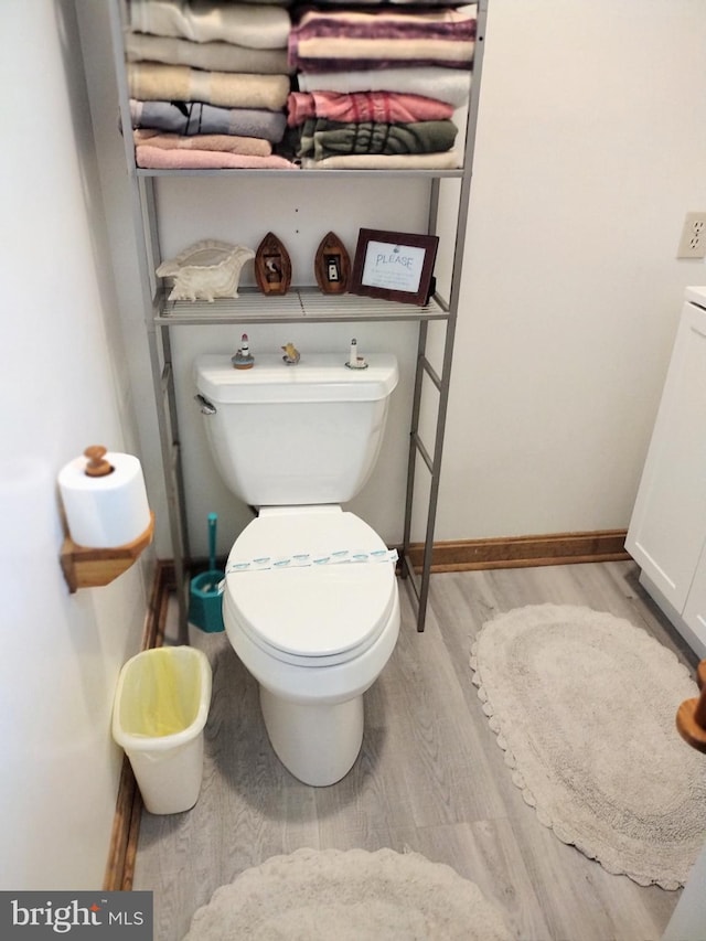 bathroom with hardwood / wood-style flooring and toilet