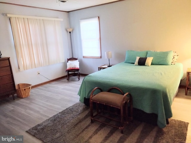 bedroom featuring wood-type flooring and crown molding