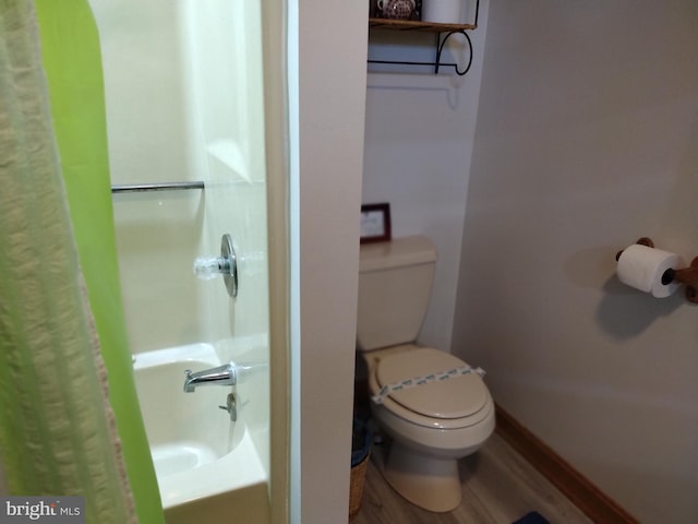 bathroom featuring hardwood / wood-style flooring, a shower, and toilet