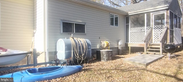 back of house featuring a sunroom and central AC