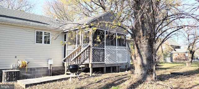 rear view of house featuring a sunroom and central air condition unit