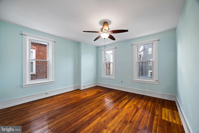 spare room featuring dark wood-type flooring and ceiling fan