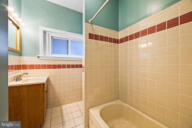 bathroom featuring tile walls, vanity, tiled shower / bath combo, and tile patterned floors