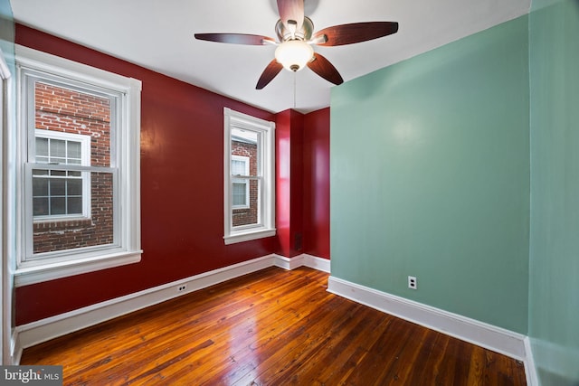 empty room with dark hardwood / wood-style floors and ceiling fan